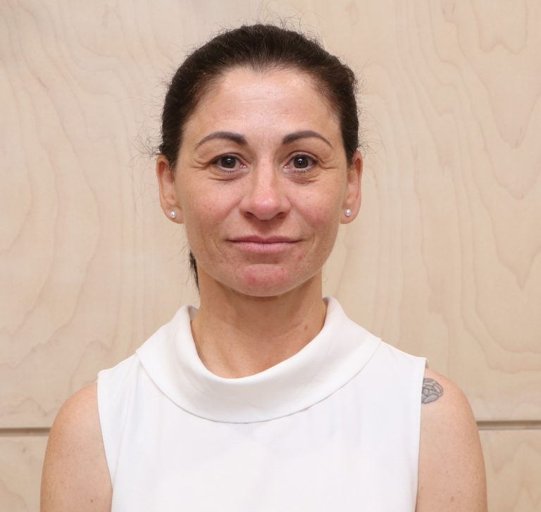 Close-up portrait of a woman with a neutral expression.