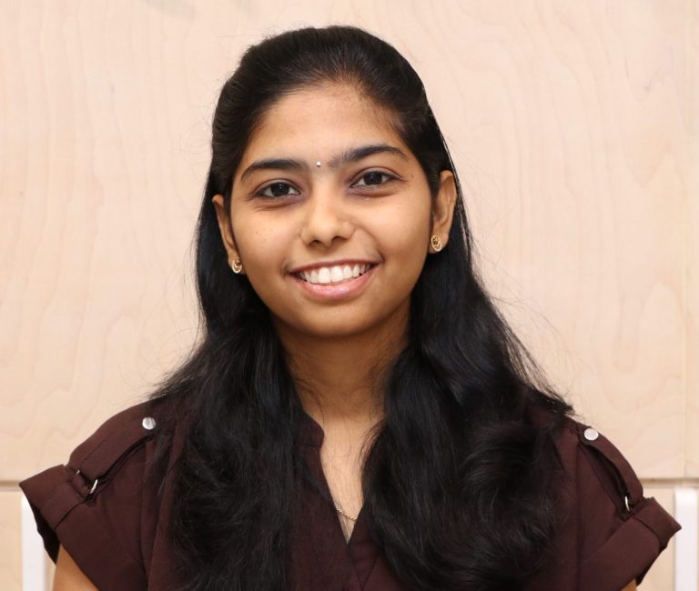 A bright portrait featuring a smiling woman with long dark hair.